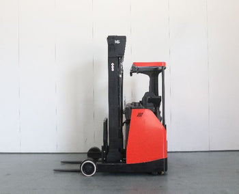 A side view of a compact red and black forklift, showcasing its tall mast, control panel, and forks on a smooth concrete floor.