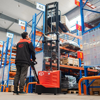 Warehouse worker in an EP-branded jacket operating a red electric pallet stacker, navigating organized blue shelving marked with location labels, in a spacious and well-lit warehouse.