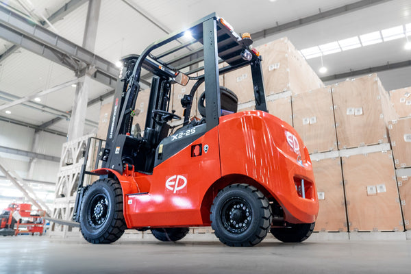 Red forklift in a warehouse with cardboard boxes