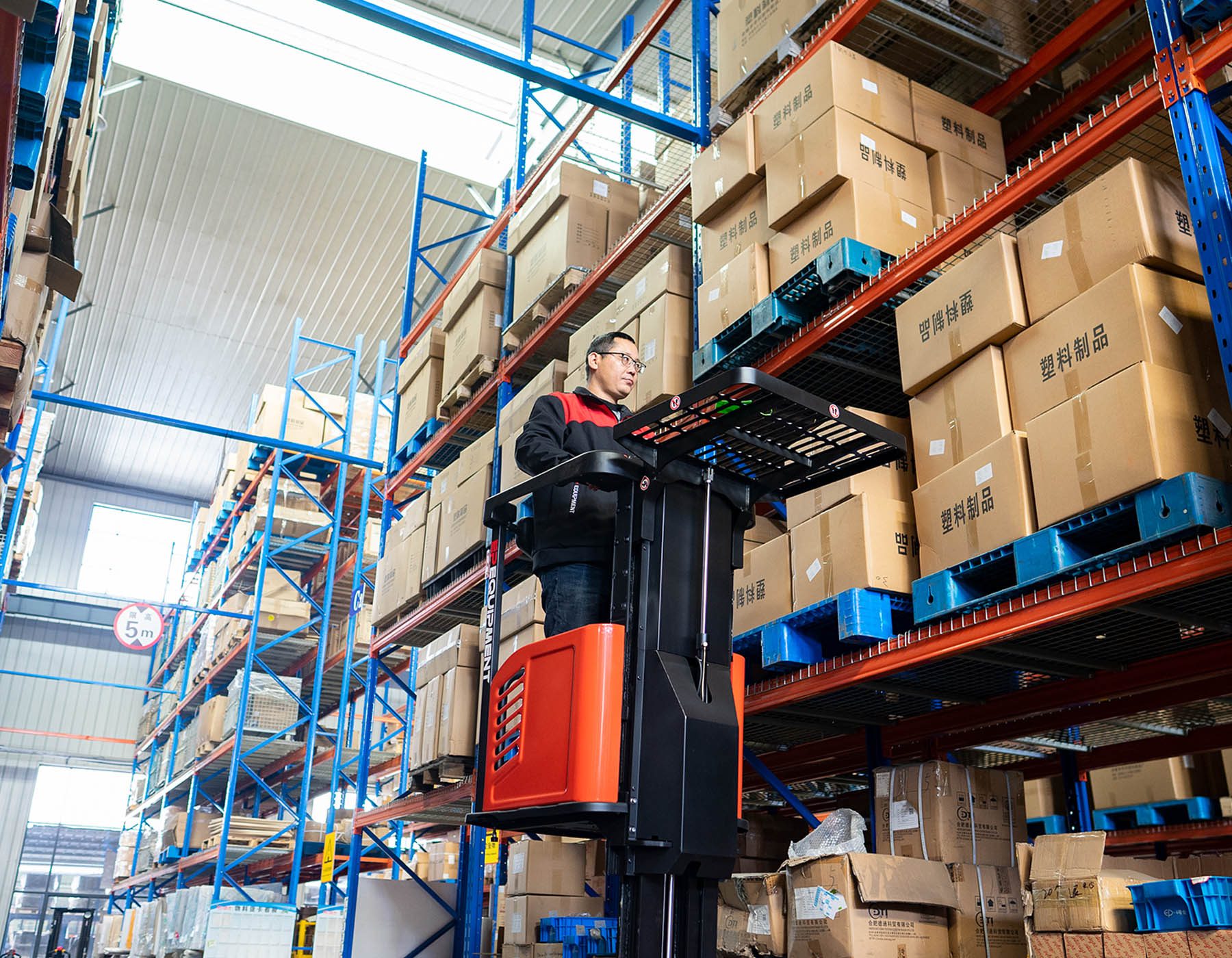 Front angled view of a red and black EP ESl122 electric stacker truck, featuring tall lifting masts and a compact handle design, positioned on a white background