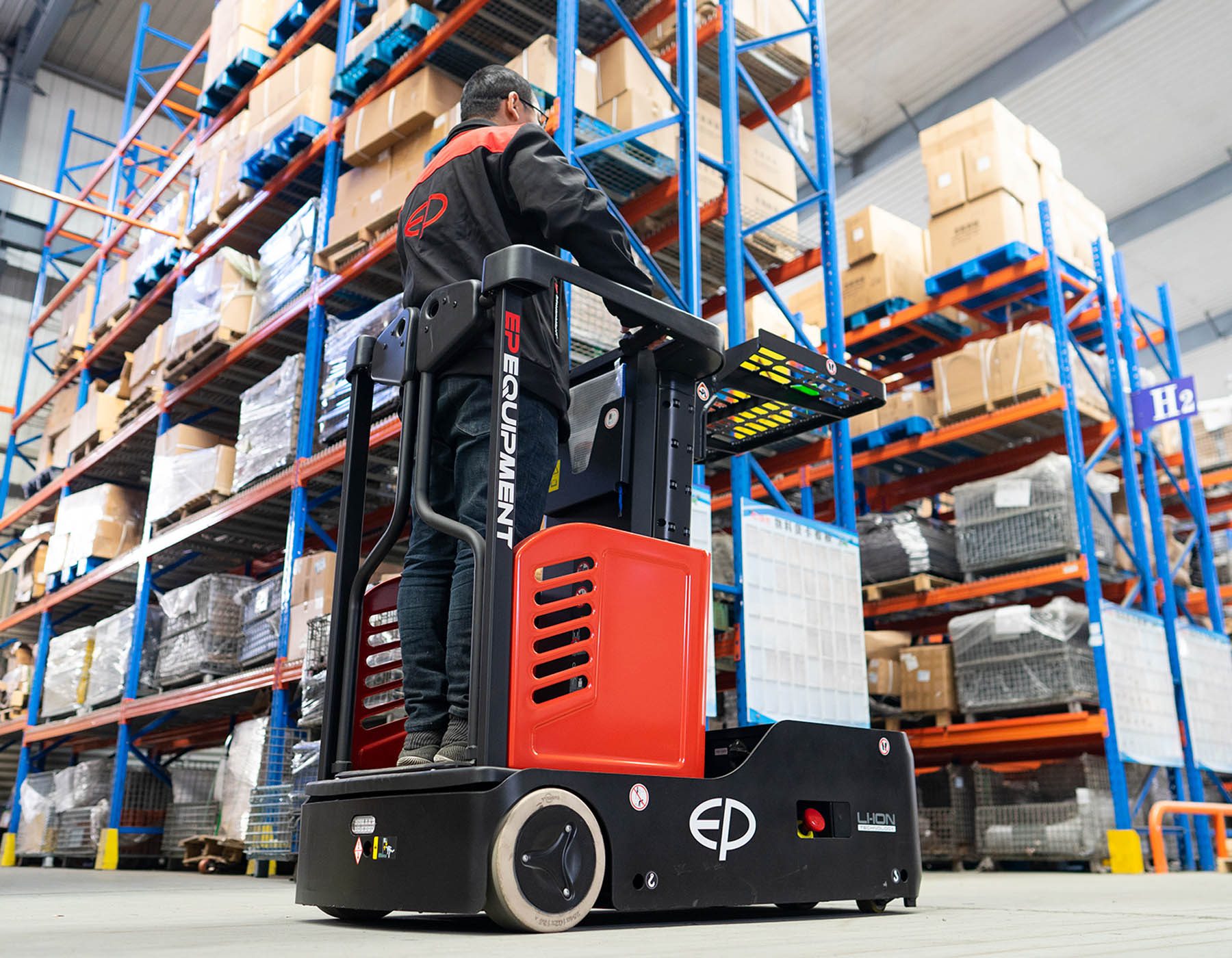 Front angled view of a red and black EP ESl122 electric stacker truck, featuring tall lifting masts and a compact handle design, positioned on a white background