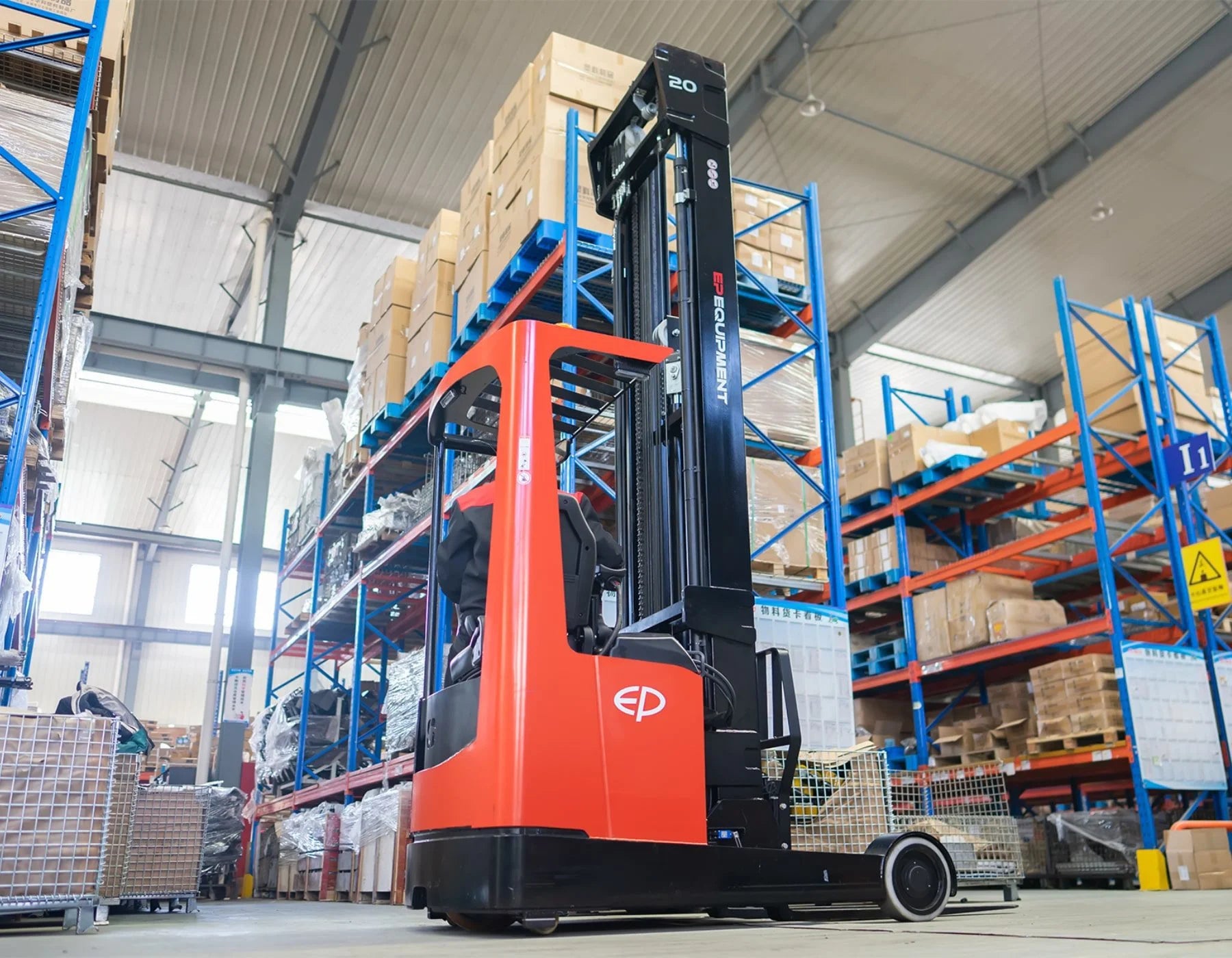 Red electric reach truck by EP Equipment in a spacious warehouse, lifting goods to high blue shelves filled with boxed and palletized items, under a high industrial ceiling